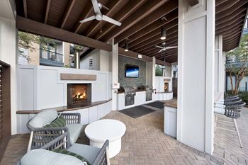 A patio with a fireplace and chairs.